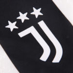 Close-up of a black fabric badge with three white stars and a white curved stripe.