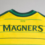 wQWQZQzlm43n8xO | UAE SPORT STORE Back of a bright yellow Celtic jersey with bold green MAGNERS lettering and small CELTIC above, green trim.
