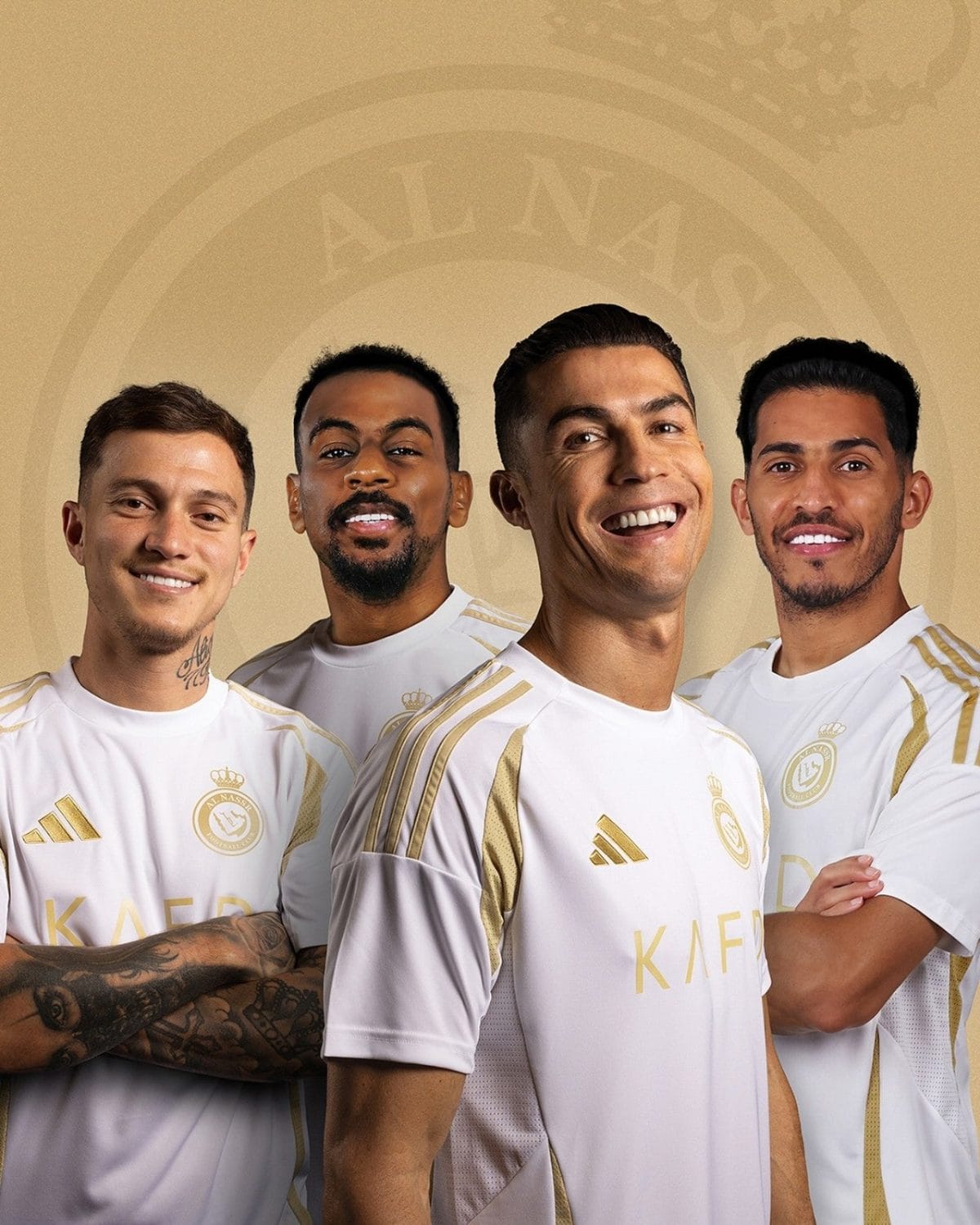 Four male soccer players in white and gold kits stand together, smiling against a beige backdrop.