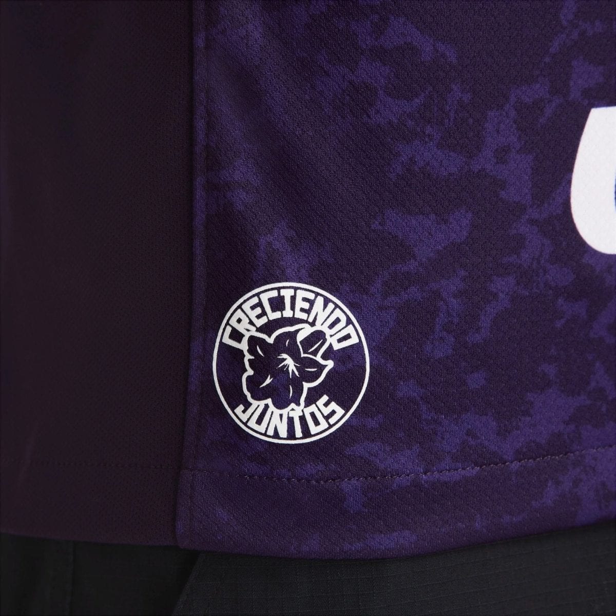Close-up of purple patterned fabric with a white circular logo of a dog and surrounding text.
