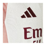 Close-up of a white mesh sports jersey with a maroon Adidas logo and partial red text.