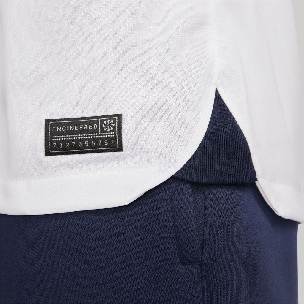 xxDGMs7jVQLM8iZ_2cd039e4-7b4f-4760-99fd-5a08dae8f2b4 | UAE SPORT STORE White shirt hem over navy trousers with a small black label reading 'ENGINEERED' and a numeric code on the left side.