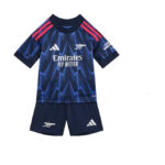 Children's blue Arsenal football kit with a zigzag pattern, Emirates Fly Better sponsor, Arsenal crest, and Adidas logos; navy shorts with Arsenal symbols.