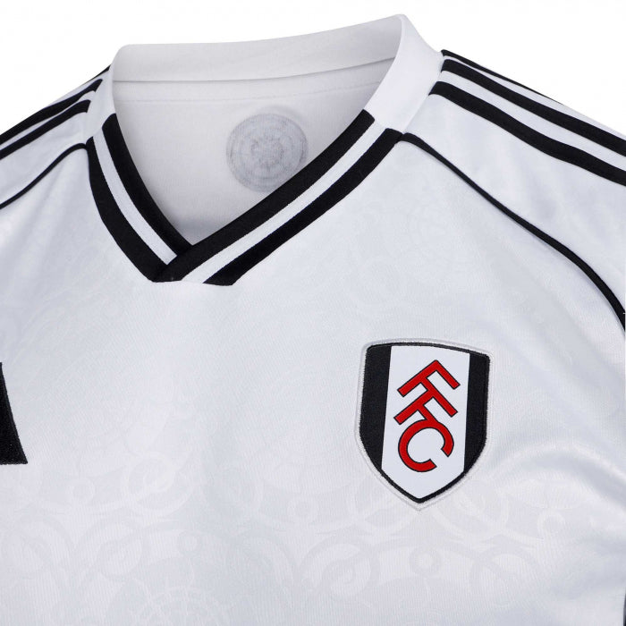 y9 | UAE SPORT STORE Close-up of a white Fulham FC football jersey with black trim and the FFC crest on the left chest.