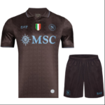 Brown gradient Napoli soccer kit: jersey with MSC sponsor, Italian flag badge, and Napoli crest; matching brown shorts with Napoli emblem and EA7 logo.