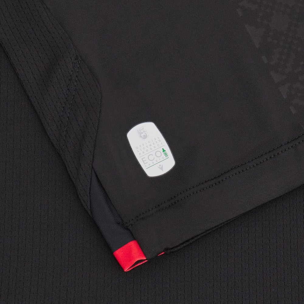 zPRRxWJwyFGJx7E | UAE SPORT STORE Close-up of black fabric with a white ECO label sticker on the sleeve and a red fabric pull tab nearby, highlighting eco-friendly branding.