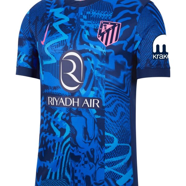 Blue patterned soccer jersey with Riyadh Air sponsor across the chest, pink Atlético Madrid crest, and a white Kraken logo on the sleeve.