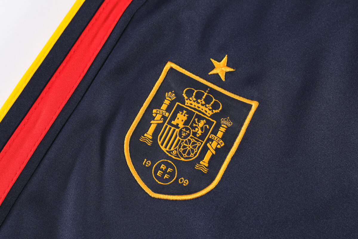 Spain national team crest on navy training quarter-zip tracksuit, 2026 season.