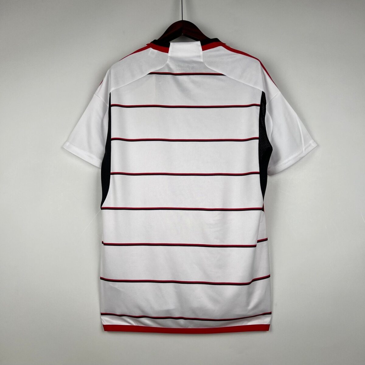 White football jersey with red and black horizontal stripes, short sleeves.
