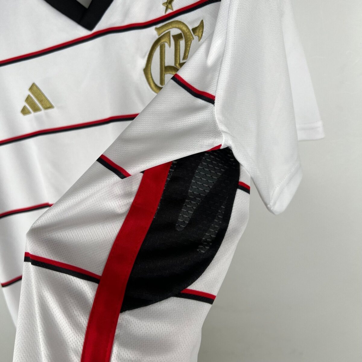 Close-up of Flamengo football jersey with red and black stripes and club logo.