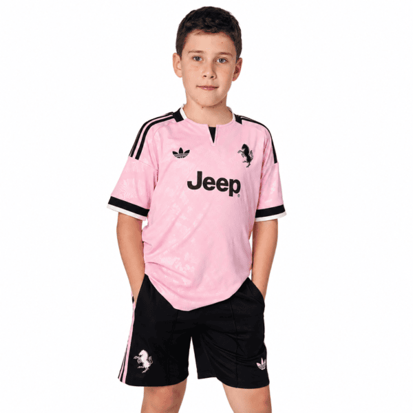 Young boy wearing Juventus away kit for kids 2026/27 in pink and black.