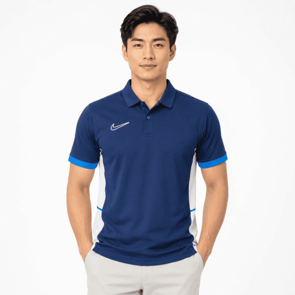 Nike Navy Training Polo Shirt - UAE SPORT STORE Man wearing a blue Nike training polo shirt with white and light blue accents.