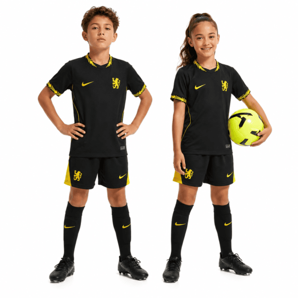 Kids wearing Chelsea away kit 2026/27 with black and yellow colors, one holding a soccer ball.