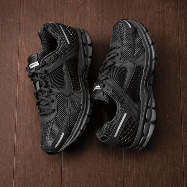 3 - UAE SPORT STORE Nike Zoom Vomero 5 Triple Black running shoes on wooden floor.