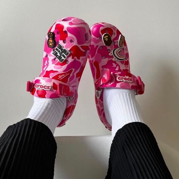 39cd14af-abd4-4344-b279-916e959a4fb0 - UAE SPORT STORE Pink camouflage BAPE x Crocs Classic Clog with patches and straps.