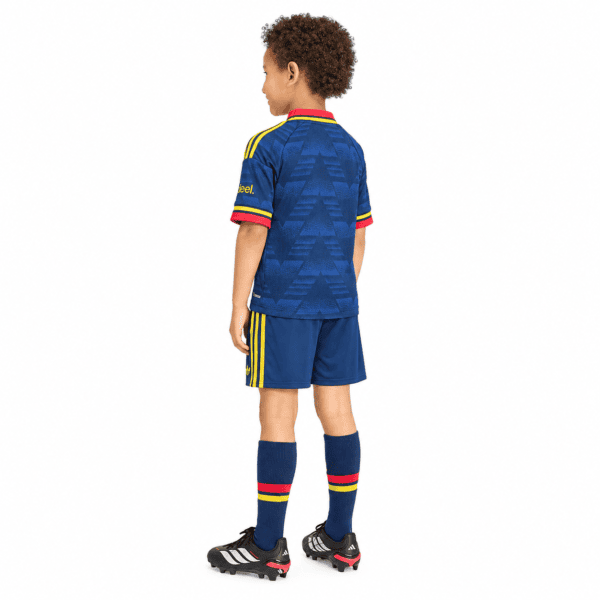 Child in Arsenal away kids football kit with blue jersey and shorts, red and yellow accents.
