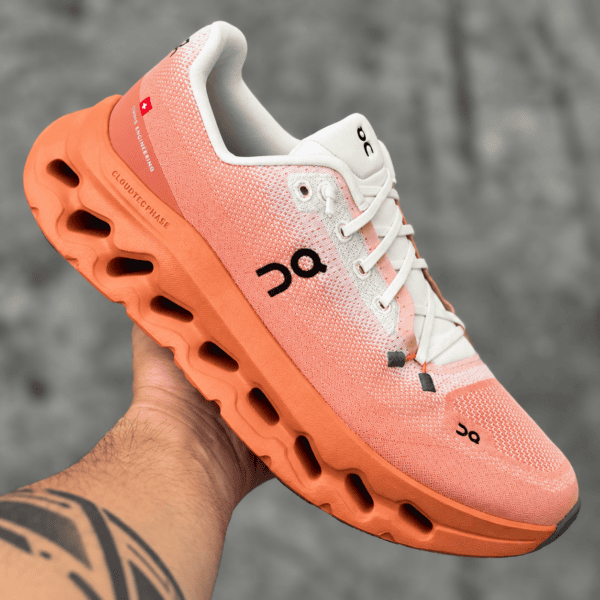 On Running Cloudtilt Ivory Canyon sneaker with orange sole and white upper.