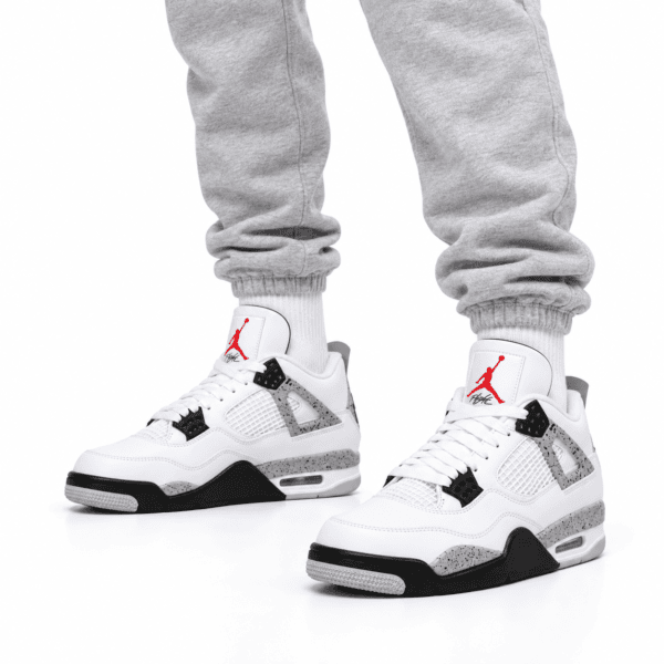 8d311224-f5e0-479f-96a6-c9bcfebb0e7a - UAE SPORT STORE White Air Jordan 4 Retro OG sneakers with red Jumpman logo and black accents.