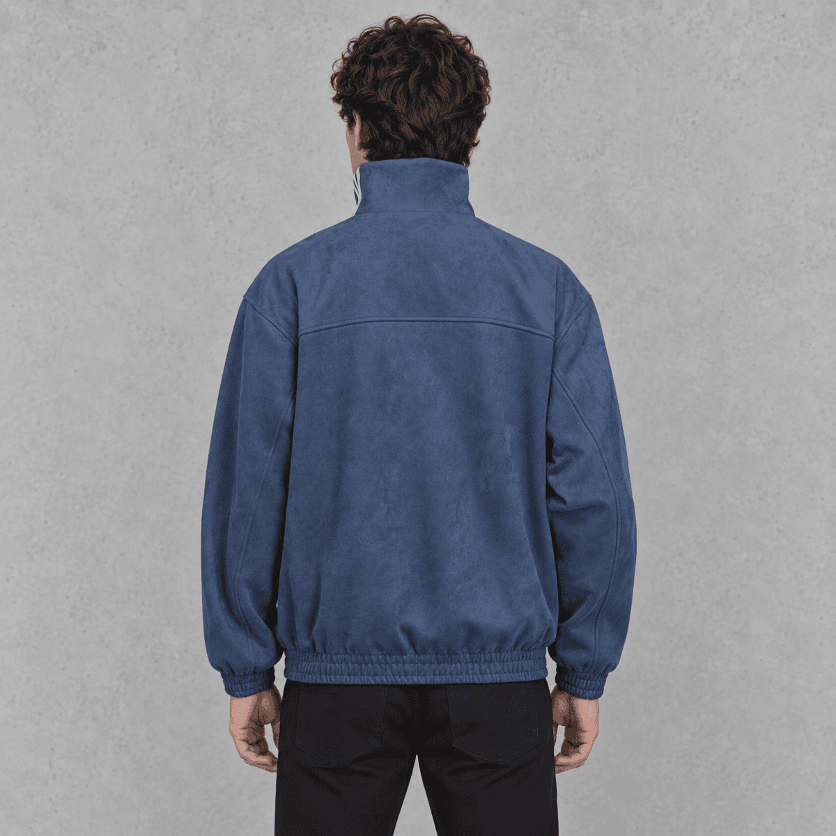 Back view of a man wearing a blue fleece jacket with a high collar.