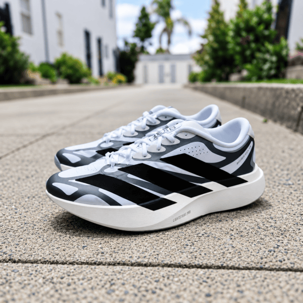 Adidas Adizero Evo SL EXO trainers in white and black on pavement.