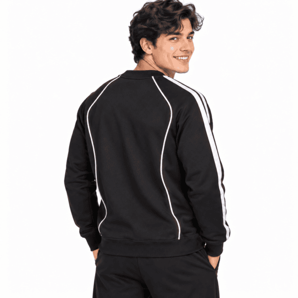 Young man wearing a black Liverpool sweatshirt with white stripes on sleeves.