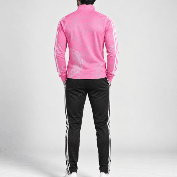 Man wearing pink tracksuit with white stripes, back view, on a plain background.