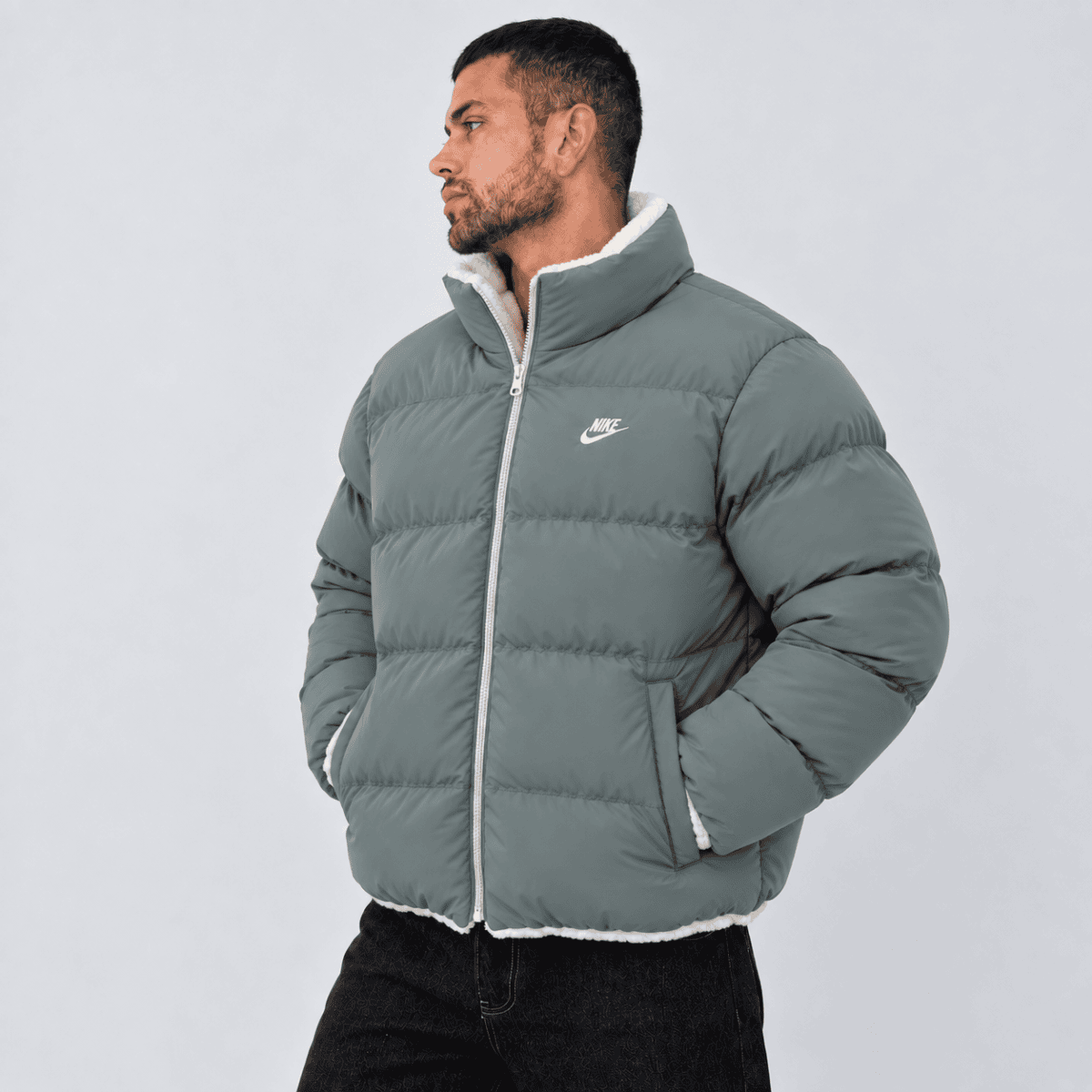 Men's Nike puffer jacket in grey with white logo and zipper, front view.