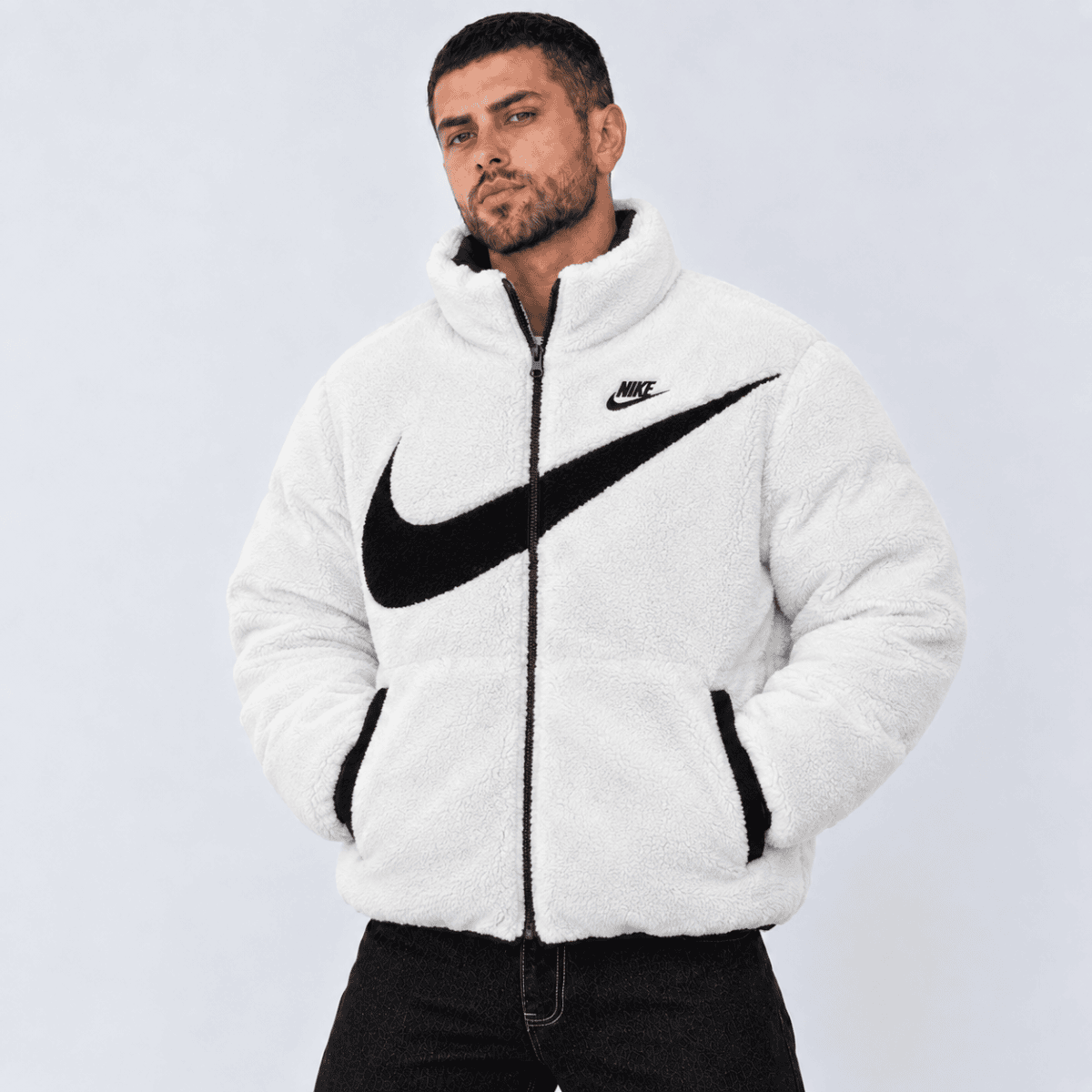Nike white fleece jacket with black swoosh logo and zip closure.