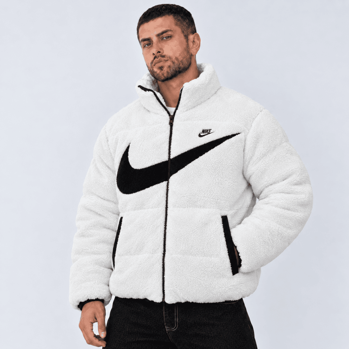 Man wearing white Nike fleece jacket with black swoosh logo.