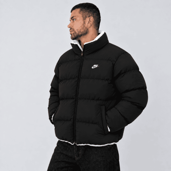 Black Nike puffer jacket with white logo and collar, front view.