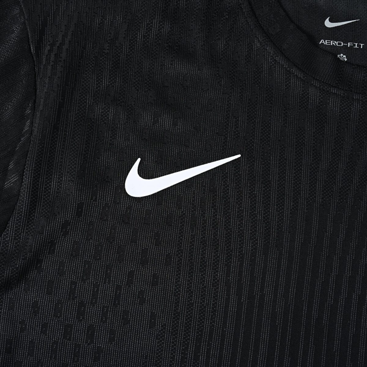 Close-up of black Nike sports jersey with white swoosh logo.