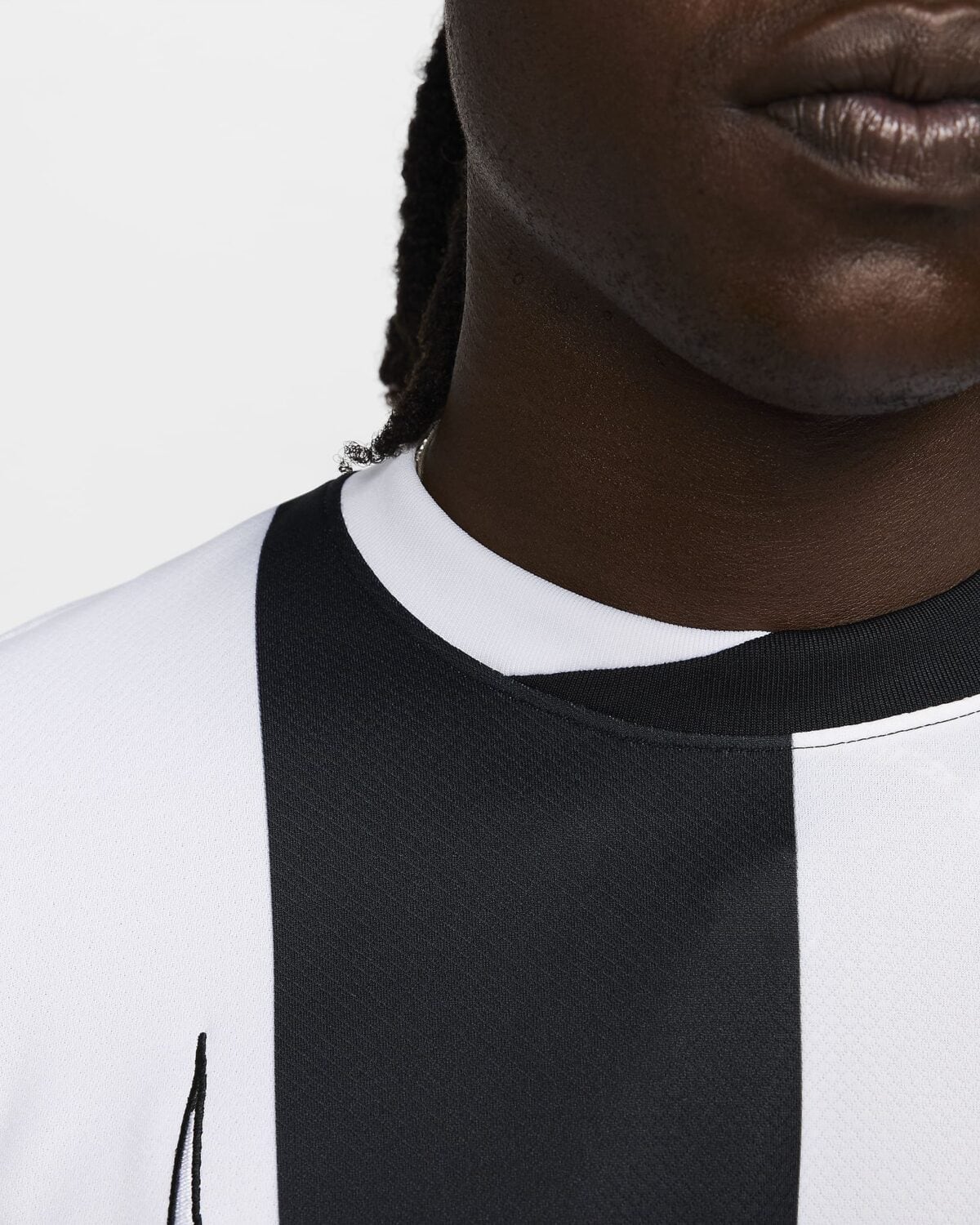 Close-up of a football jersey with black and white vertical stripes.