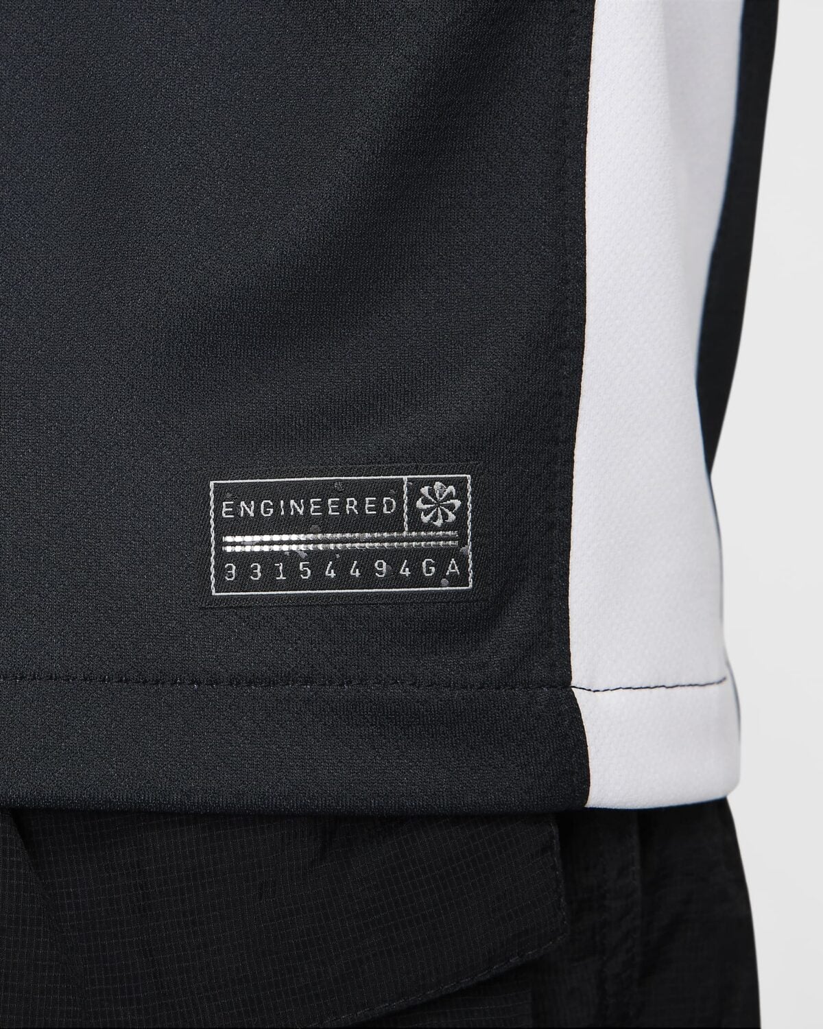 Close-up of black sports jersey with 'Engineered' label and serial number.