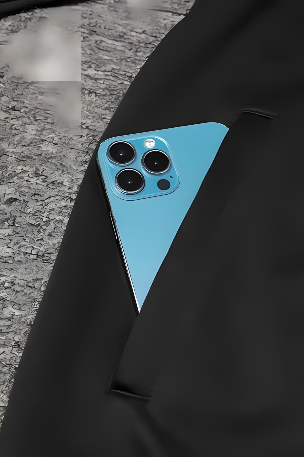 Blue smartphone with triple camera on black backpack on gray surface.
