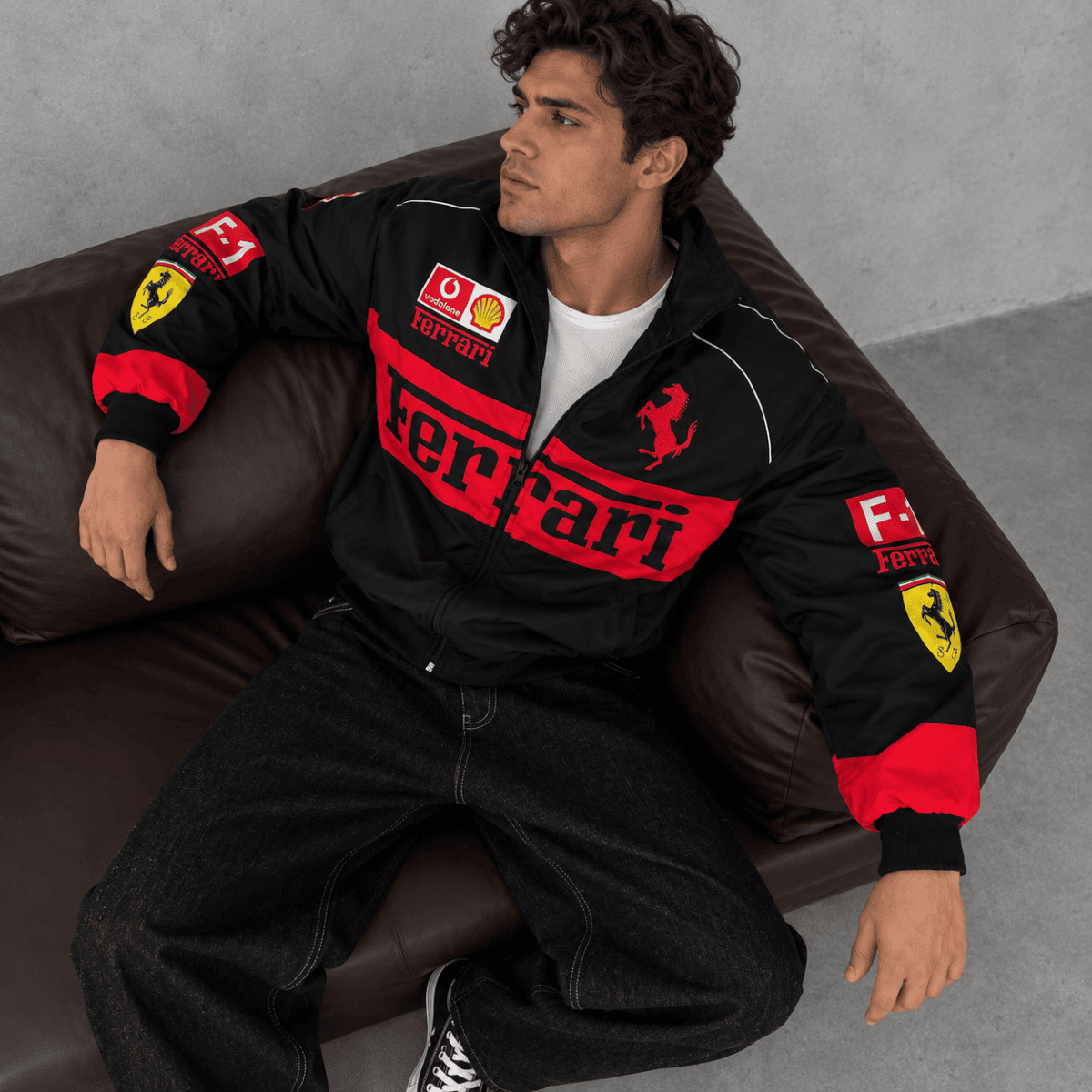 Man wearing Ferrari Formula 1 team jacket with logos and red accents.