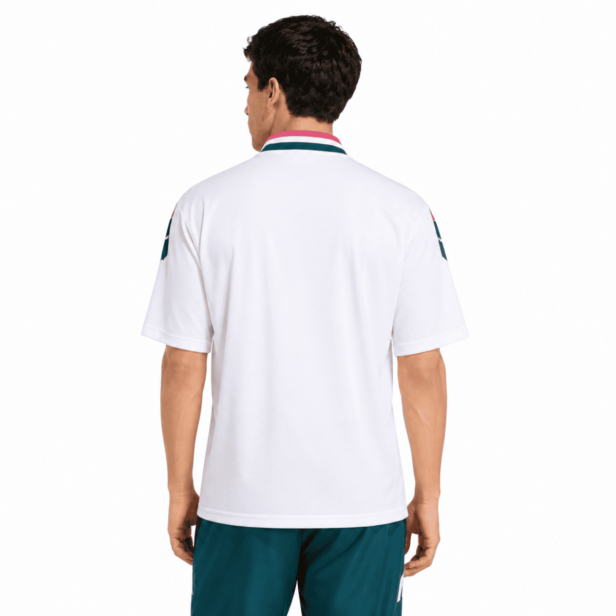 Back view of a man wearing a white Real Madrid jersey with teal shorts.