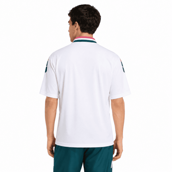 Back view of a man wearing a white Real Madrid jersey with teal shorts.