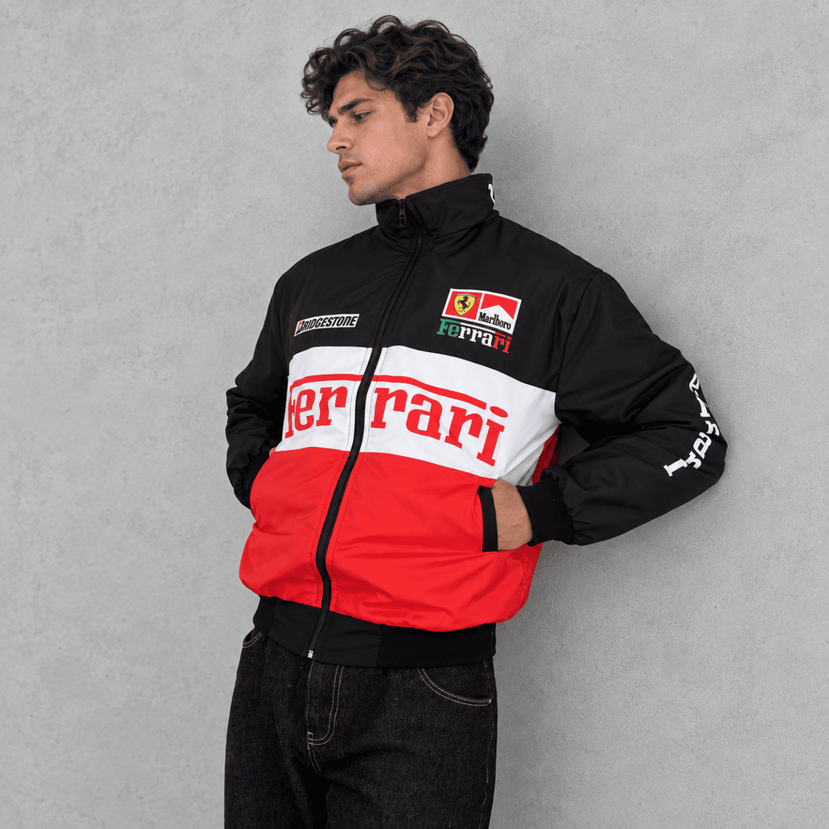 Man wearing Ferrari racing jacket with black, white, and red colors.