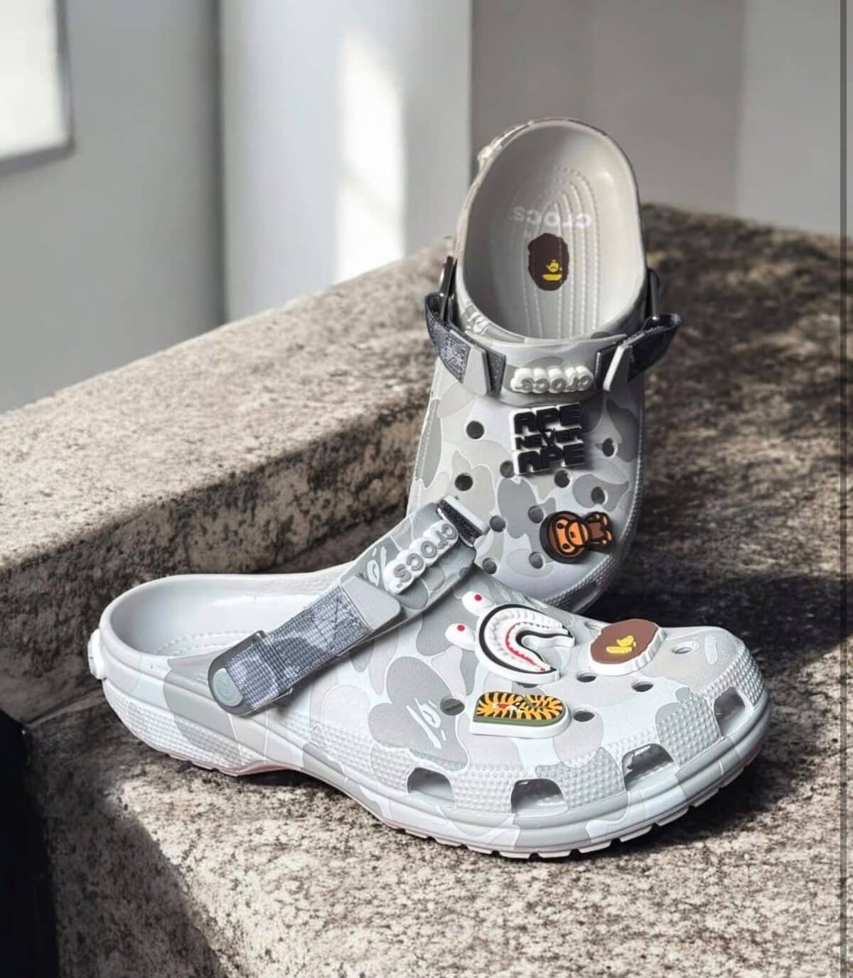 BAPE x Crocs Classic Clog in grey camouflage with patches and straps.
