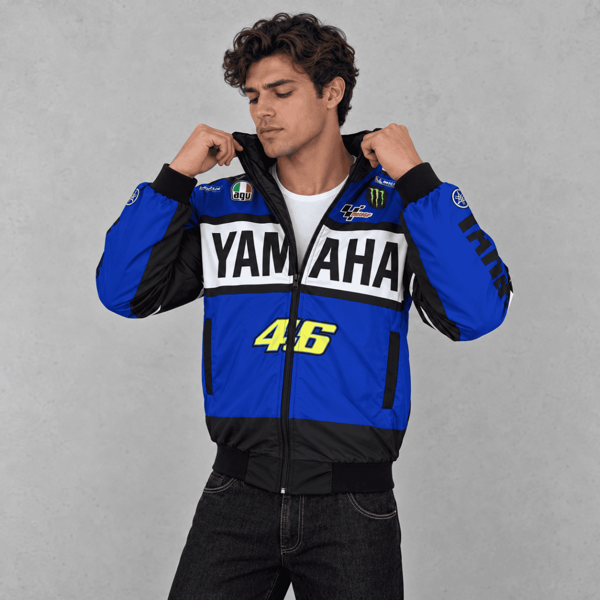 Man wearing Yamaha MotoGP racing jacket with blue, black, and white colors.