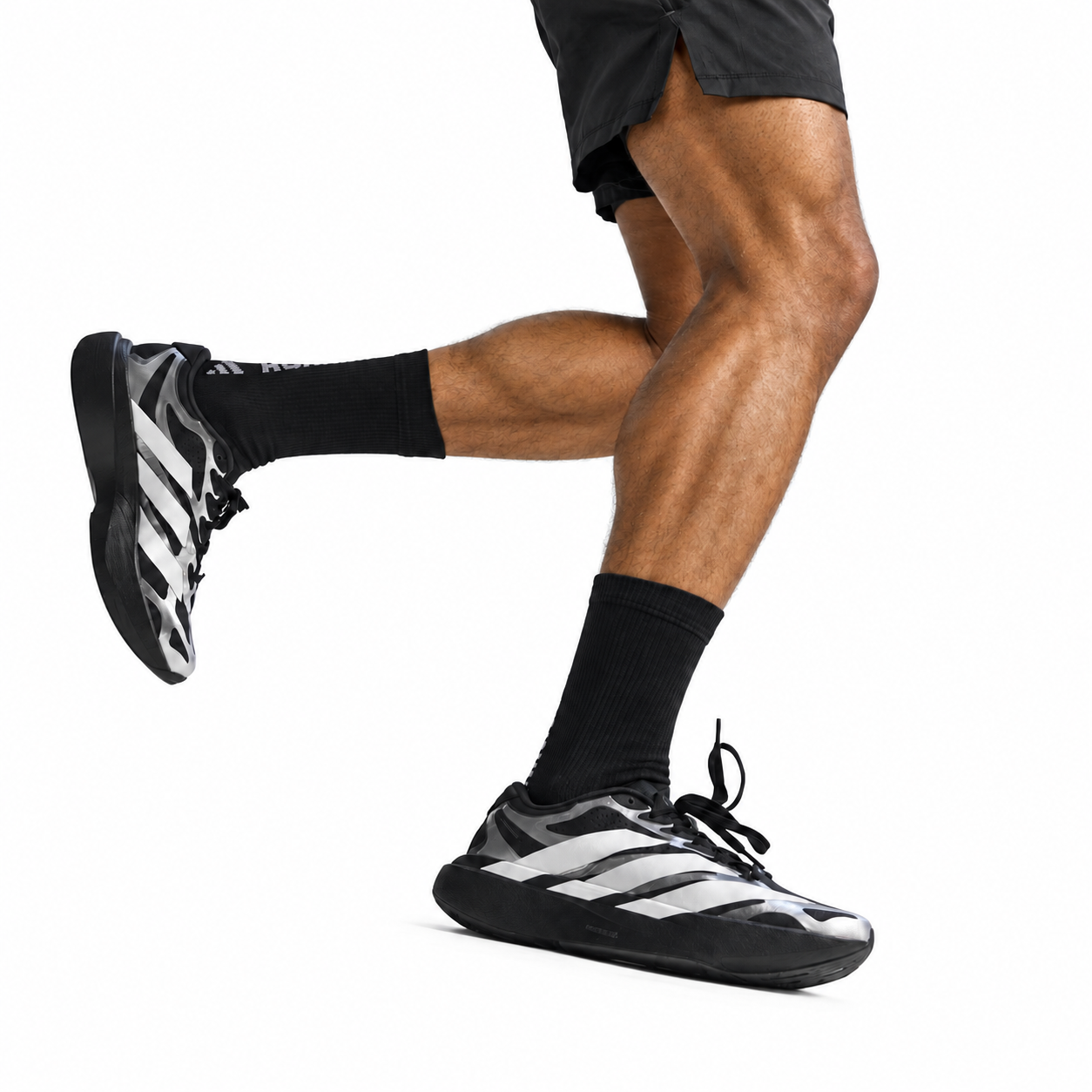 e8a87838-c1b7-4a7e-95ac-a672eae709b2 - UAE SPORT STORE Close-up of a person wearing black shorts, black socks, and black and white running shoes.