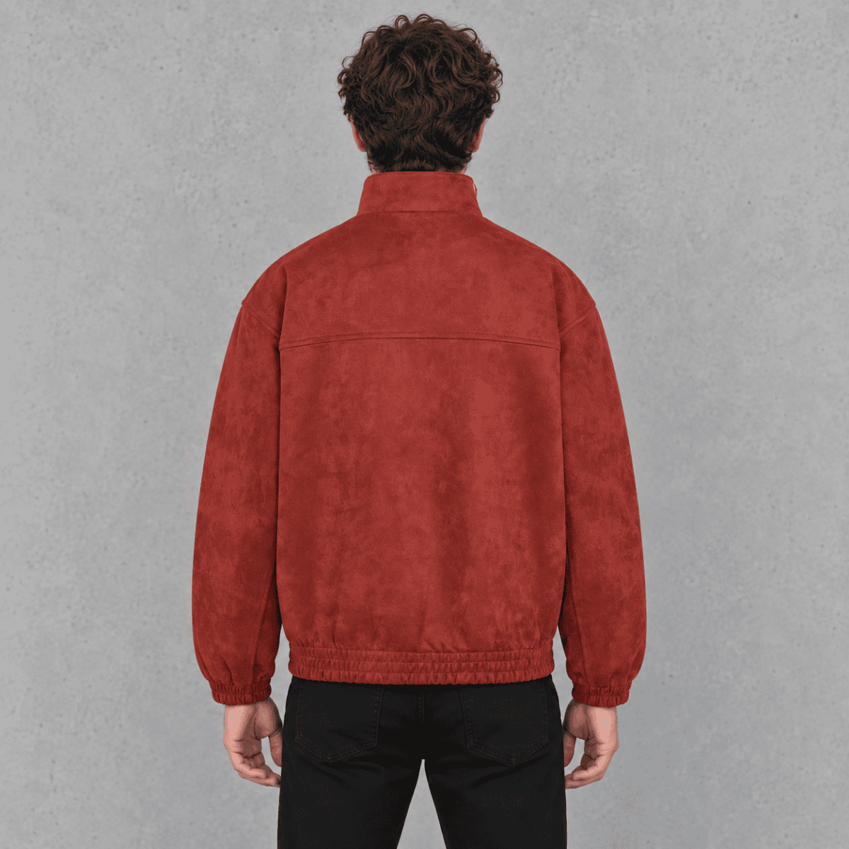 Back view of a man wearing a red suede bomber jacket and black jeans.