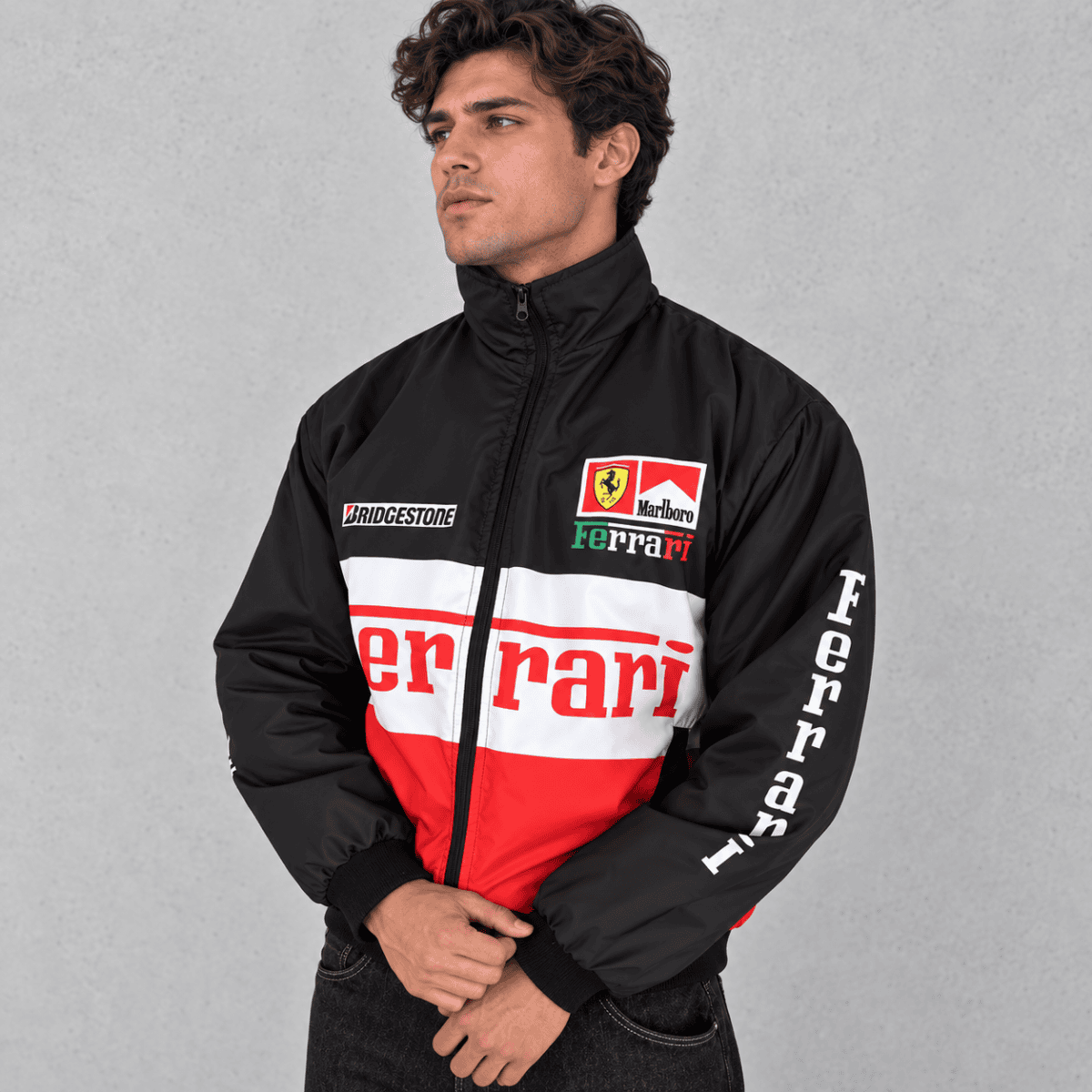 Man wearing Ferrari Formula 1 team jacket with sponsor logos and red, black, white colors.