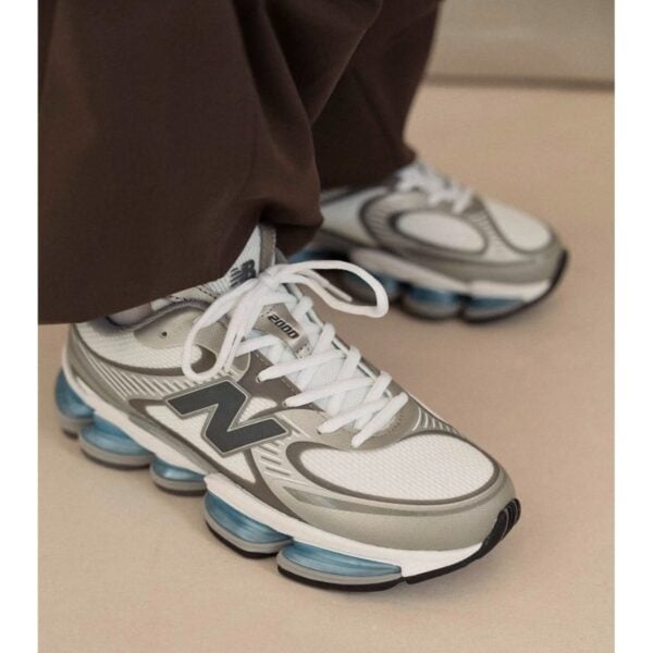 New Balance Abzorb 2000 White Grey Blue sneakers worn side view with blue Abzorb sole - UAE SPORT STORE New Balance Abzorb 2000 White Grey Blue sneakers worn side view with blue Abzorb sole