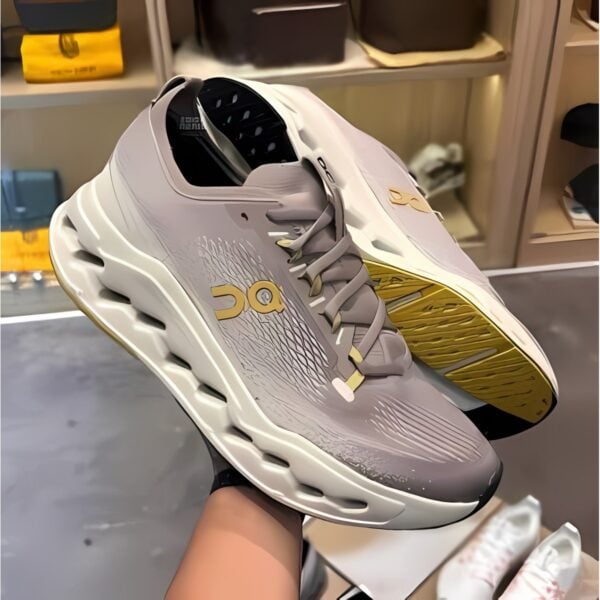 White and gold sports shoes with black accents on display in a store.