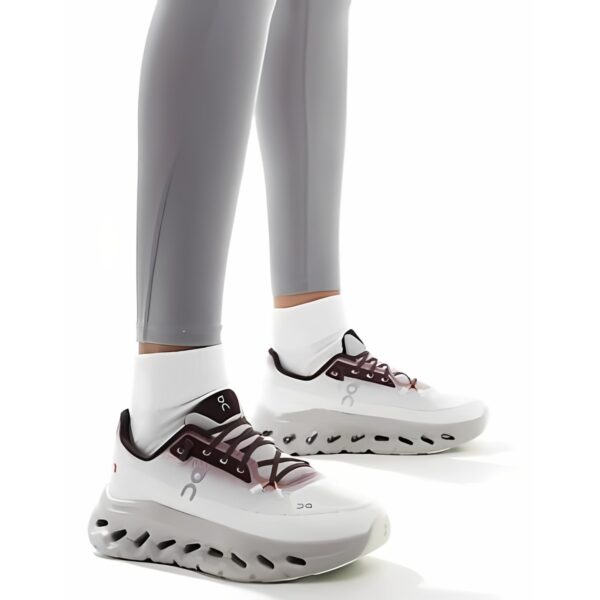 White sports shoes with black and brown accents and white socks on mannequin legs.