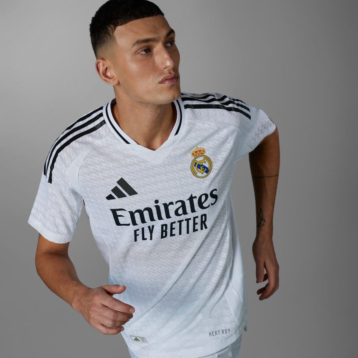 Real Madrid away kit 2023 white jersey with black stripes and logo.