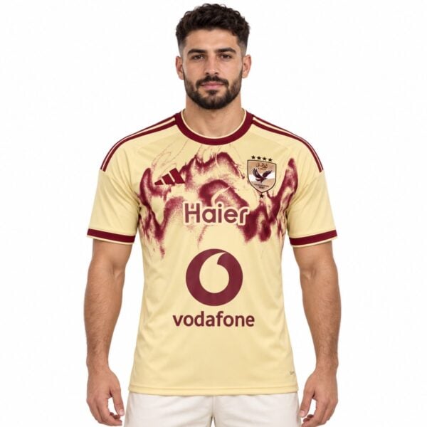 Al Ahly third jersey 2026 2027 sand gold front view with burgundy spray graphic and club shield - UAE SPORT STORE Al Ahly third jersey 2026 2027 sand gold front view with burgundy spray graphic and club shield