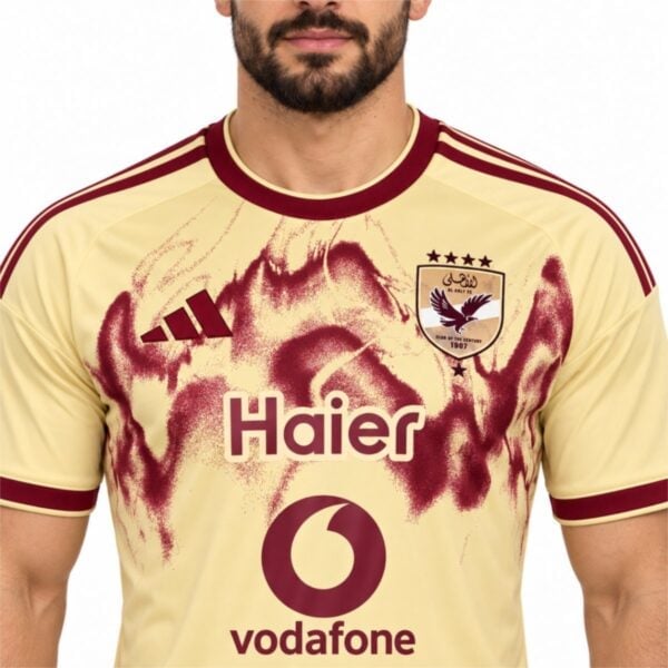 Al Ahly third jersey close-up of the club shield with four gold stars and the burgundy spray paint detail