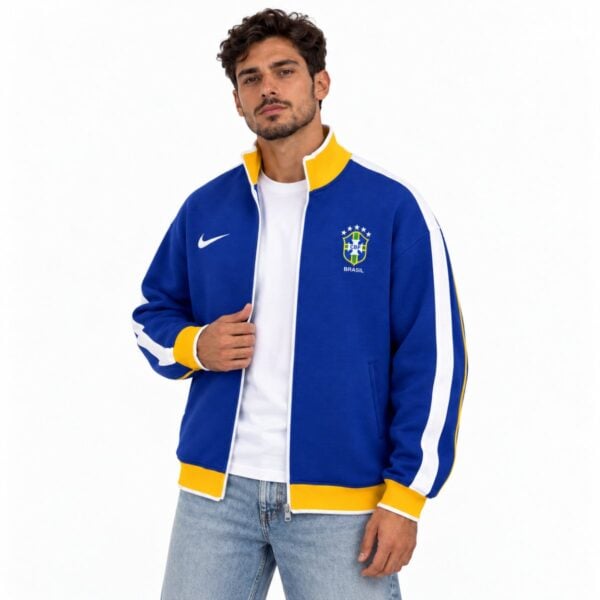 Brazil CBF blue track jacket worn open over a white tee showing the embroidered crest and Nike swoosh